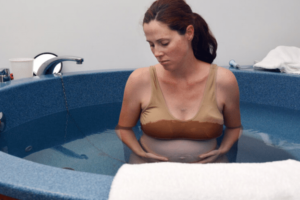 mulher realizando parto dentro de banheira