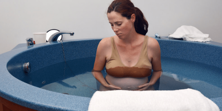 mulher realizando parto dentro de banheira
