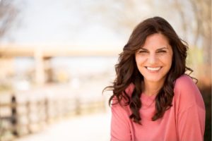 foto de mulher sorrindo sobre pacote de atendimento da saúde da mlher na clínica sim