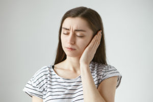Imagem de pessoa com dor de ouvido tratamento e sintomas
