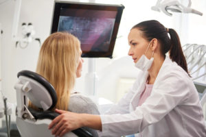 dentista-conversando-com-mulher-preocupada-durante-exame-dentario