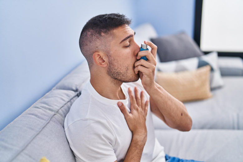 Jovem usando inalador por causa da asma