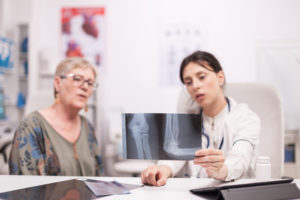 médica analisando o quadro de osteoporose da paciente