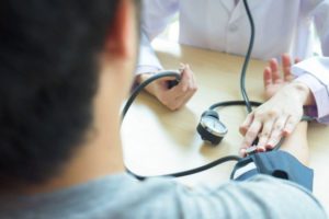 Médico verifica pressão do paciente para realização de exames do coração
