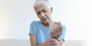 Idosa sente dores devido à artrite reumatoide