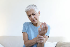 Idosa sente dores devido à artrite reumatoide